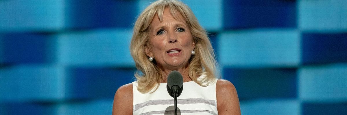 First Lady Jill Biden stands in front of a microphone as she delivers a speech
