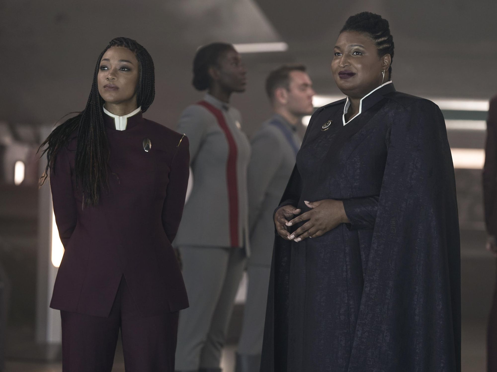 Stacey Abrams in long black robes stands next to Sonequa-Martin Geren in a purple uniform.