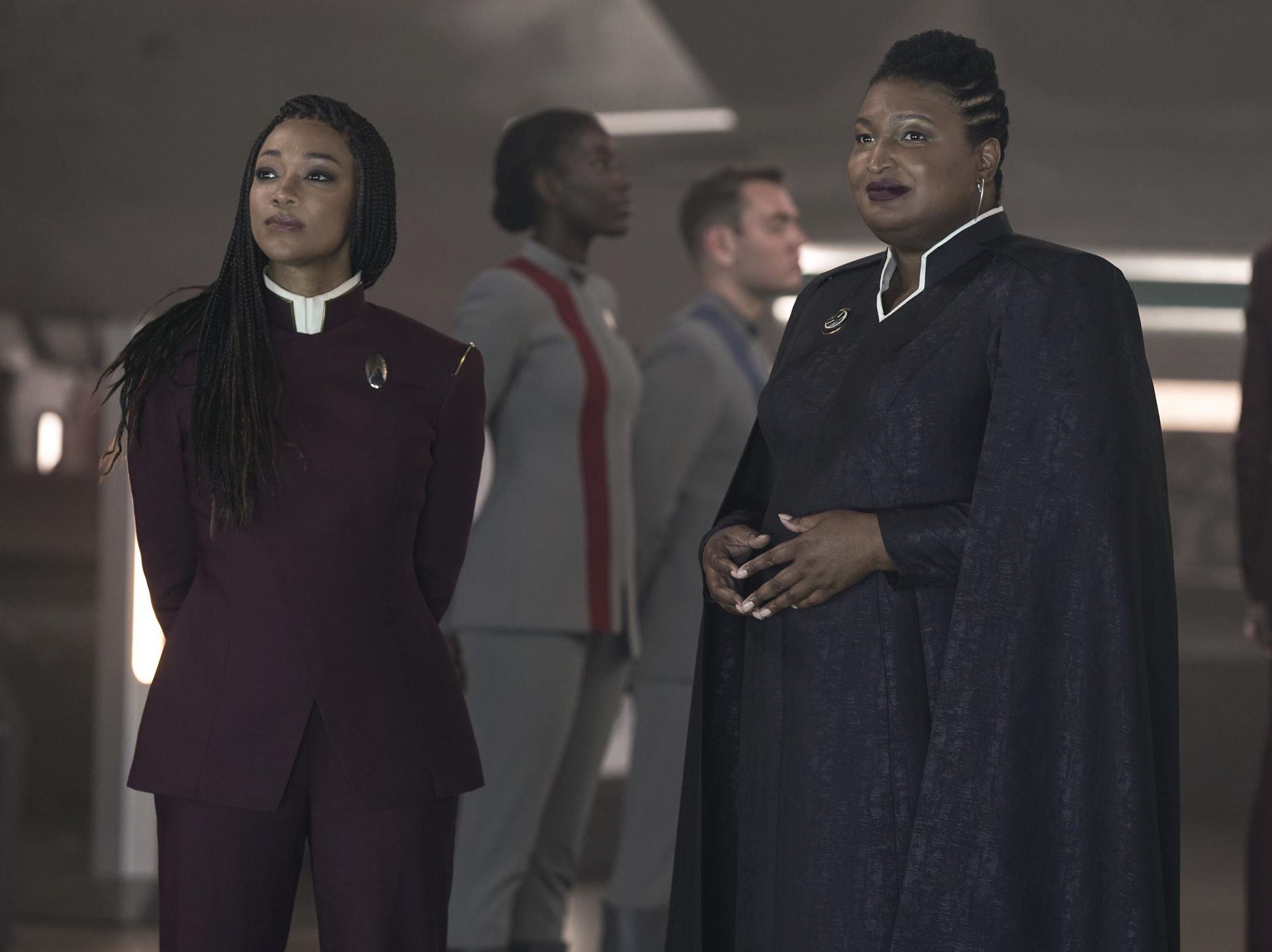 Stacey Abrams in long black robes stands next to Sonequa-Martin Geren in a purple uniform.