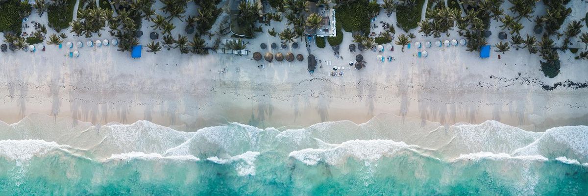 aerial photo of a Tulum, Mexico white sand beach and turquoise clear ocean water 