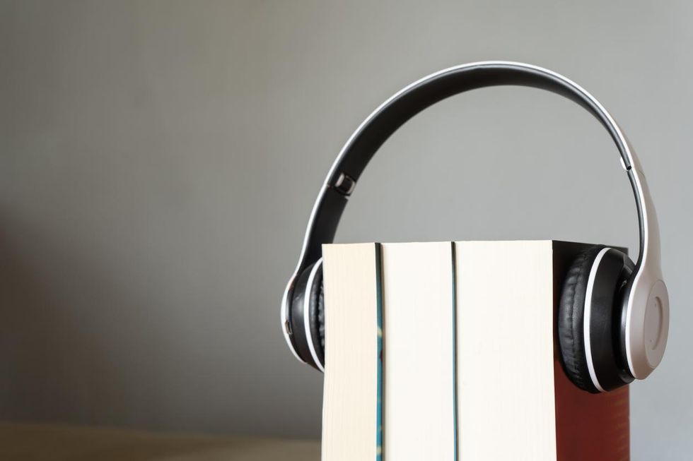 a photo of headphones around books that simulate audiobooks