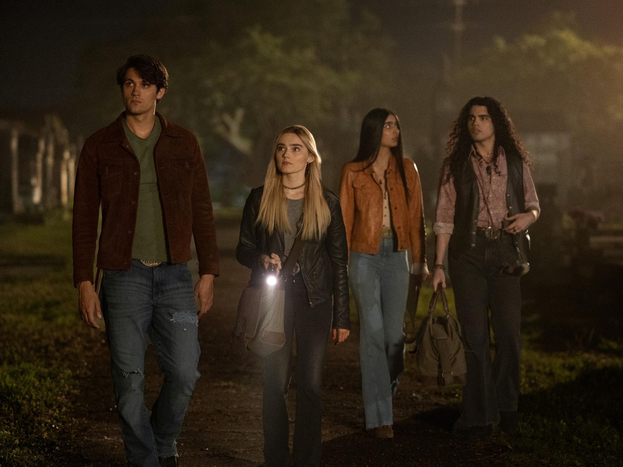 John Winchester and Mary Campbell walk down a dark path with their friends Latika Desai and Carlos Cervantez.