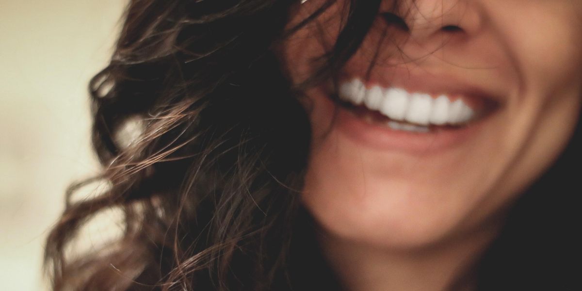 long dark haired woman smiling close-up photography