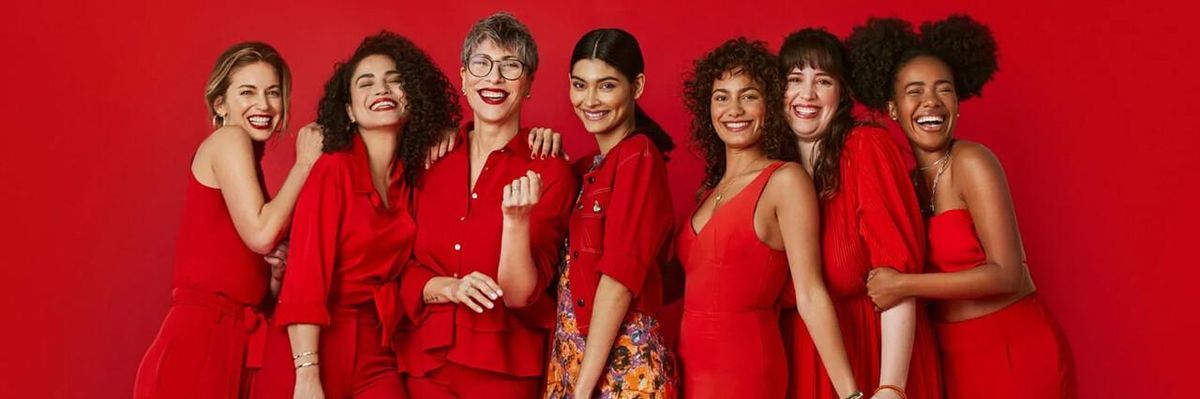 seven latina women dressed in red smile at the camera
