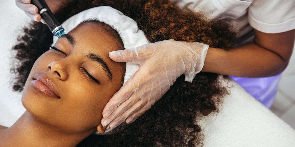 Close up of Black woman's face receiving facial treatment
