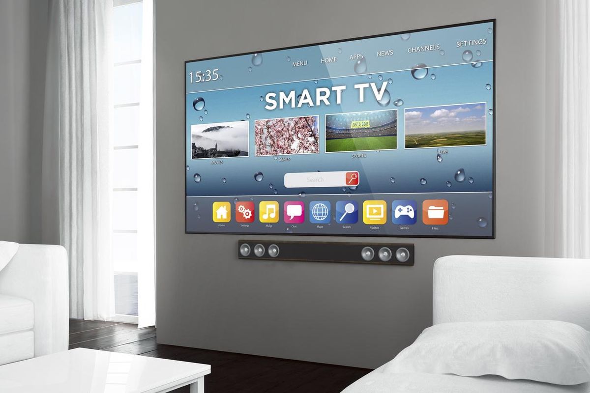 A photo of a large smart tv on a wall with a soundbar underneath
