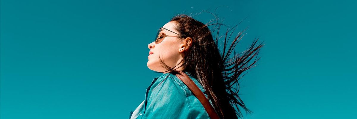 girl wearing sunglasses over a blue sky