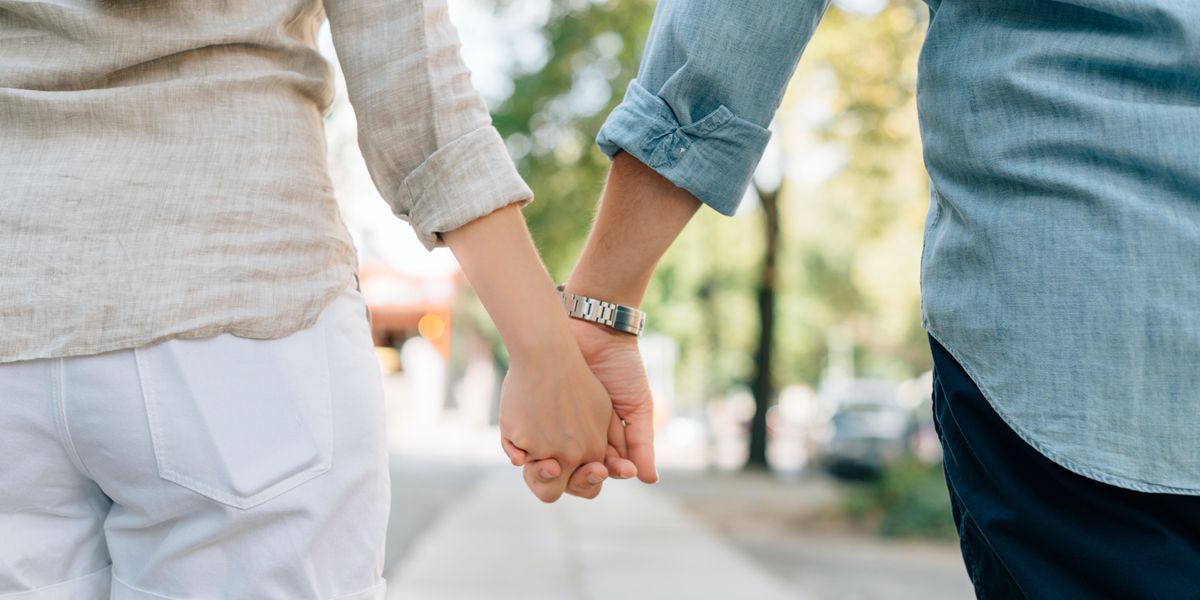 two people holding hands together on walkway during daytime