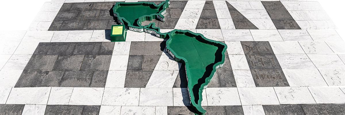 United States, Central America, and South America as large green cut outs on a concrete floor 