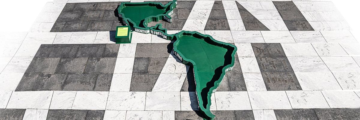 United States, Central America, and South America as large green cut outs on a concrete floor