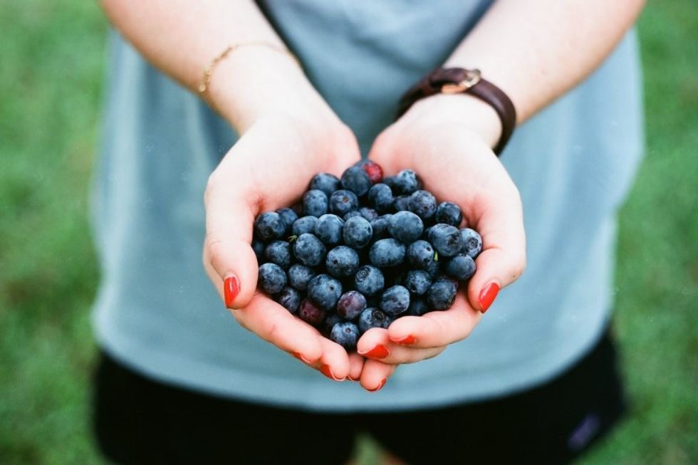 woman holding blueberries in her hands