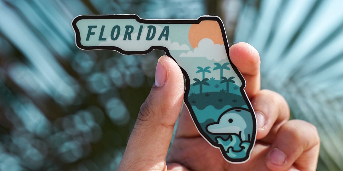 Person holding up magnet of Florida
