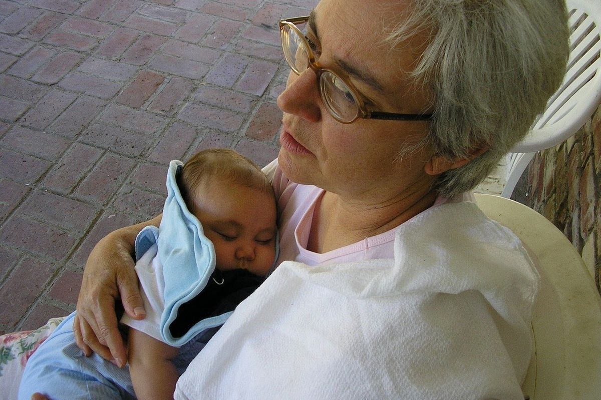 A middle-aged woman holding a baby.