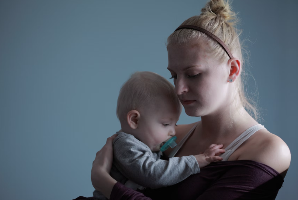 a young mother holds her baby
