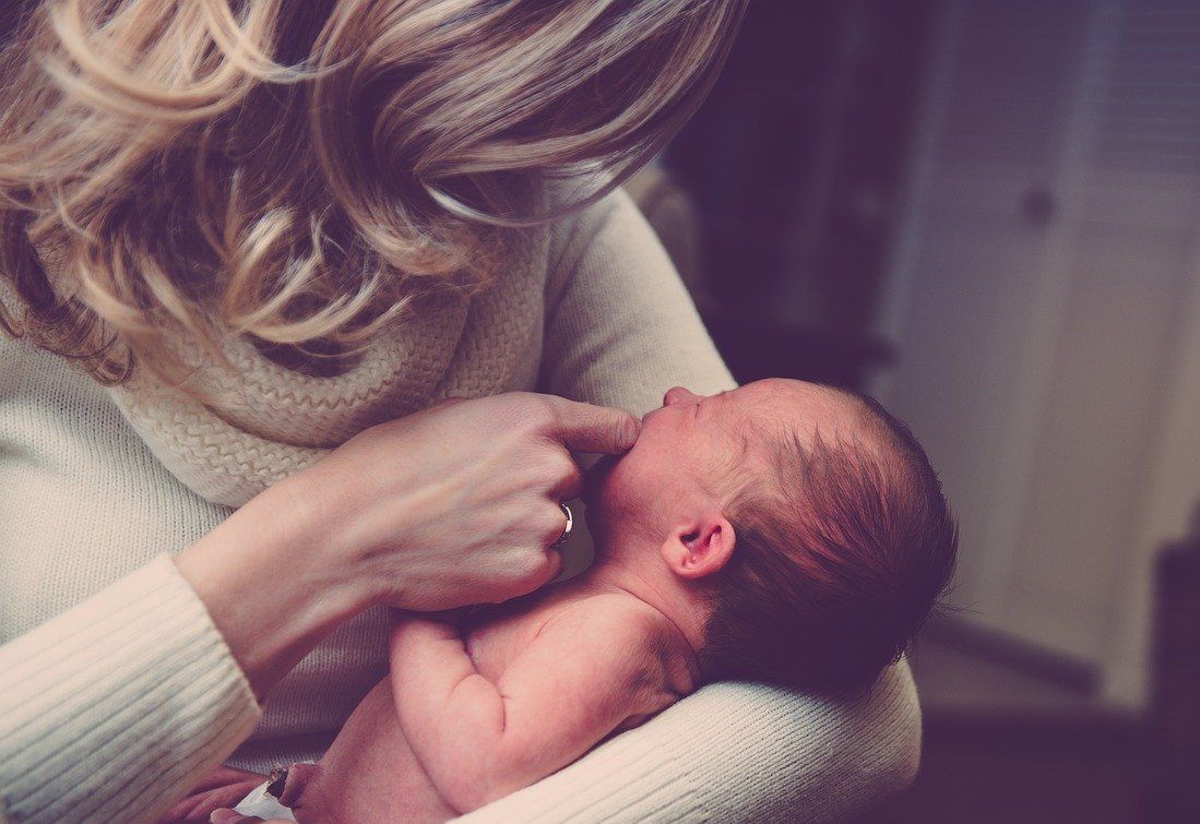 A woman holds a newborn baby.