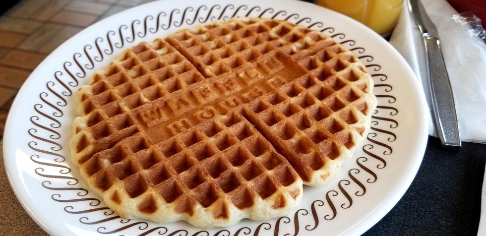 Waffle sits on white plate with fork at Waffle House.