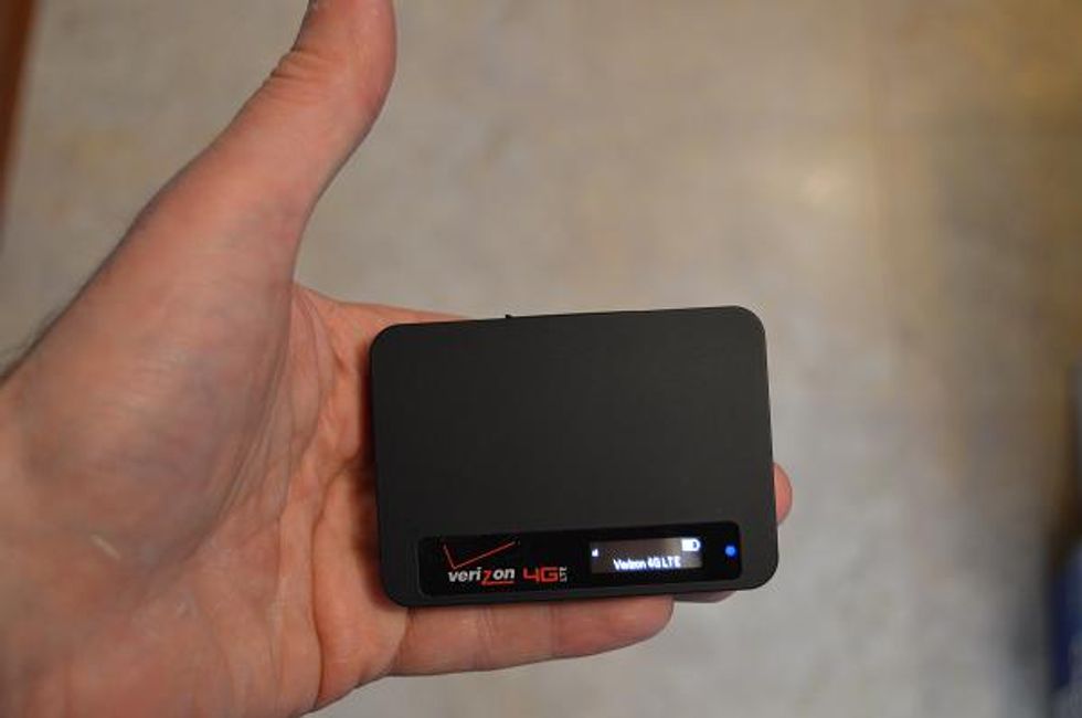 a photo of a man holding a Verizon 4G LTE hotspot