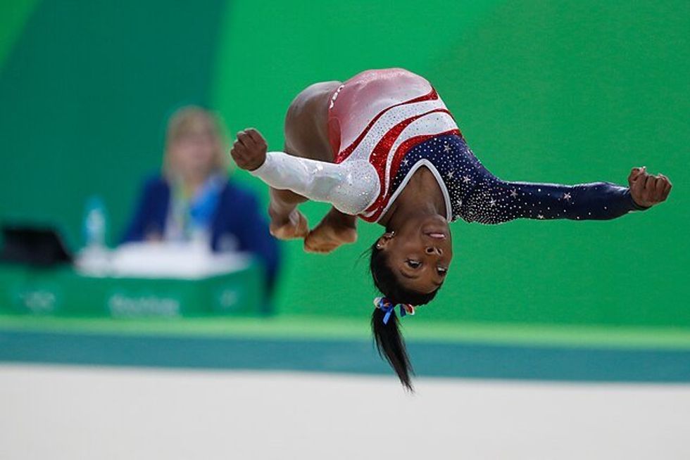 Simone Biles upside down in the air