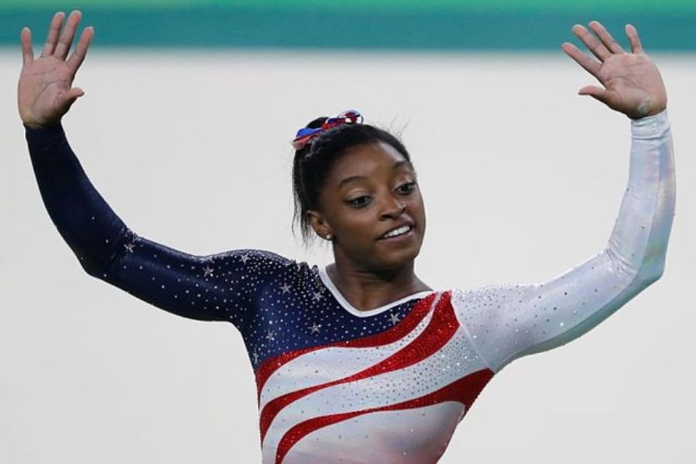Simone Biles holding her hands up