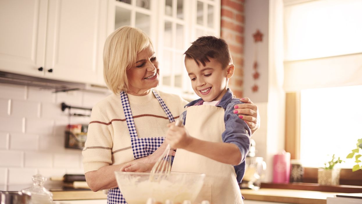 A grandmother compliments her grandson while baking in the kitchen.