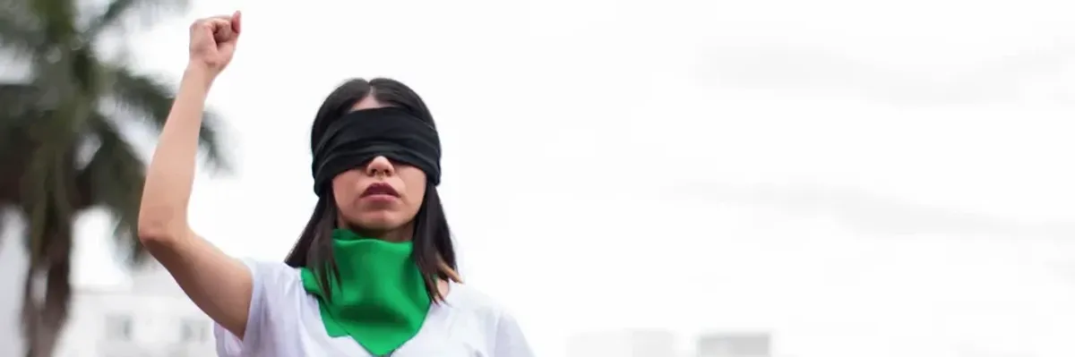 an image of a woman wearing a green handkerchief and a black blindfold