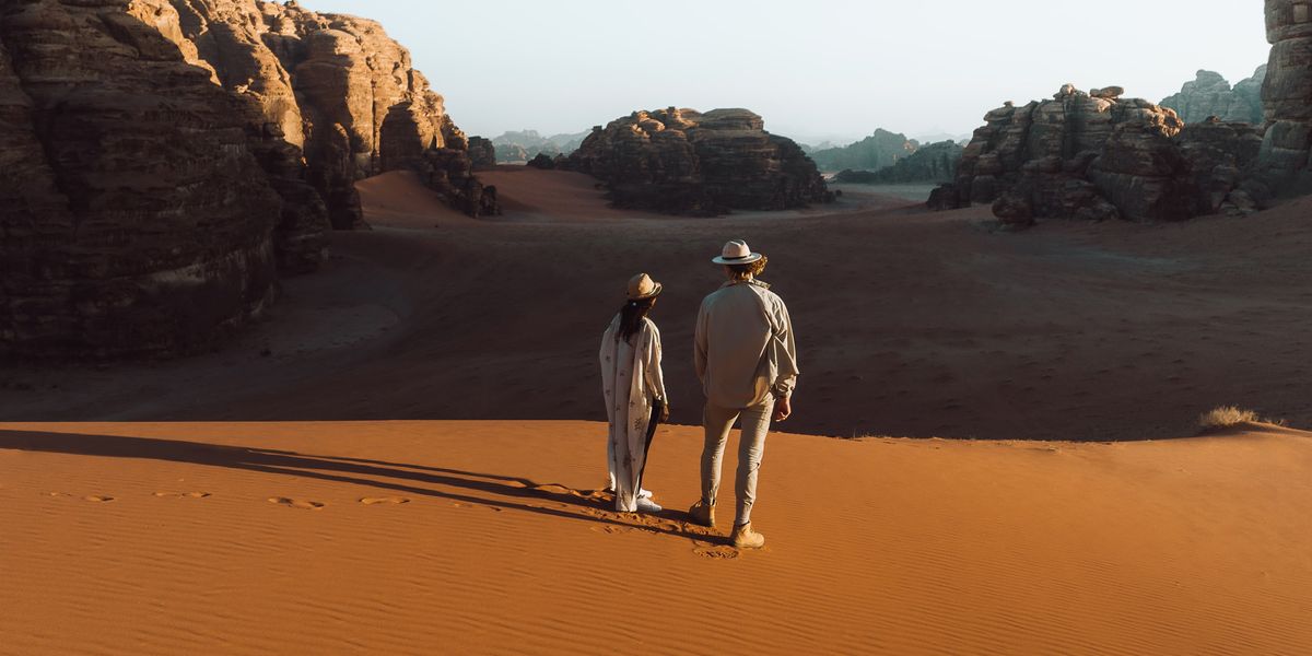 a man and a woman walking in the desert