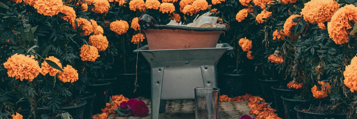 flowers, a glass and other items for an ofrenda 