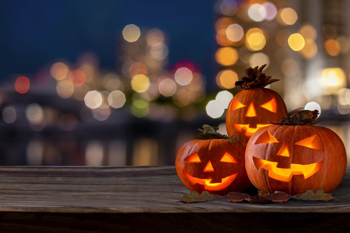 pumpkins lit up outside on a wooden shelf