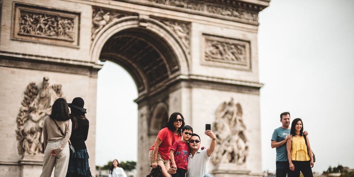 Family taking a picture in front of the Arc de Triomphe