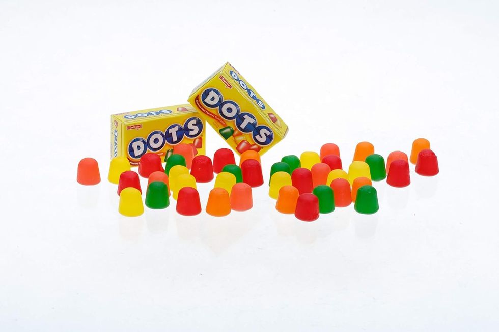 Two boxes of Dots candy surrounded by green, yellow, orange and red Dots