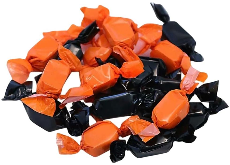 A pile of Peanut Butter Kisses in black and orange wrappers.