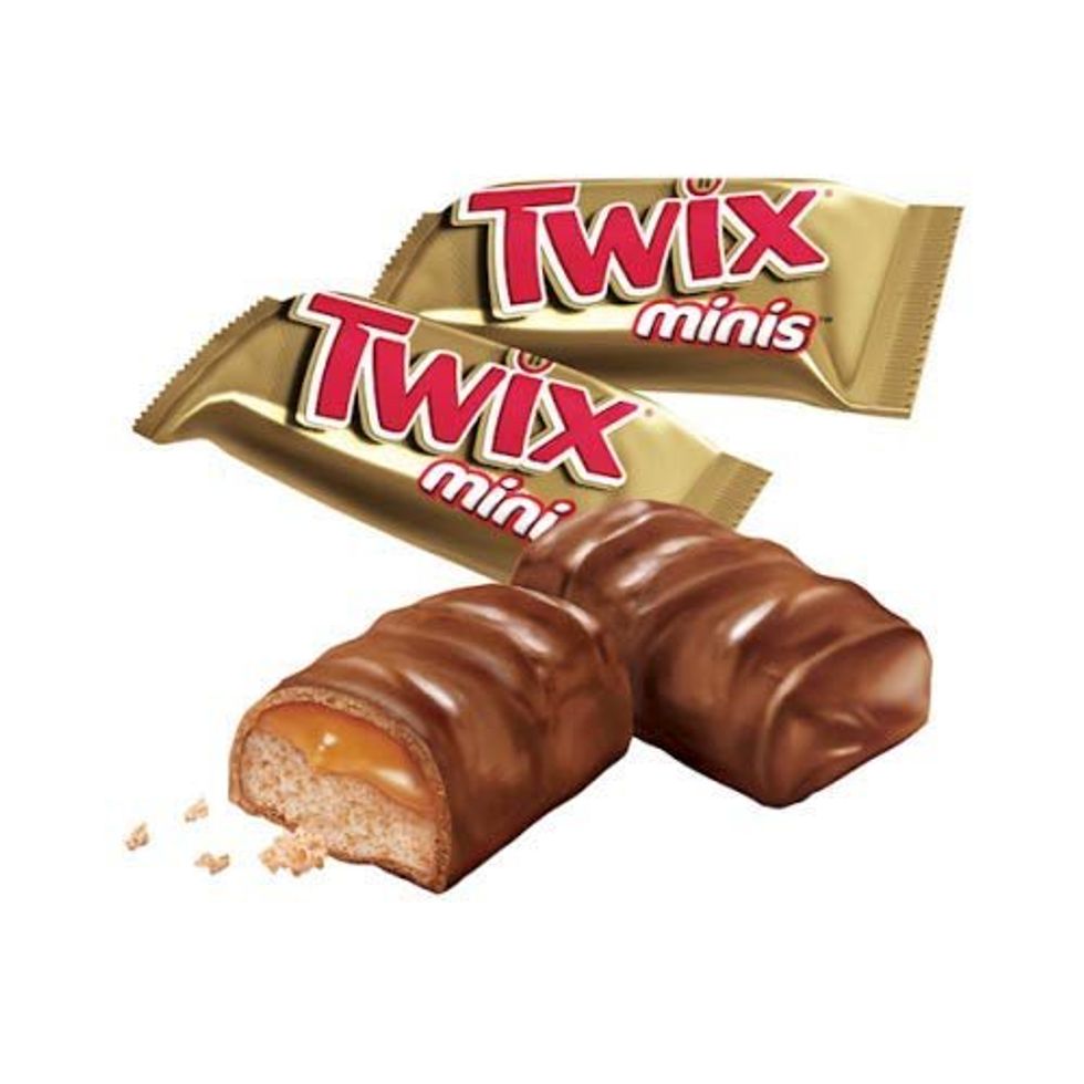Two Twix minis sit next to their gold wrappers.
