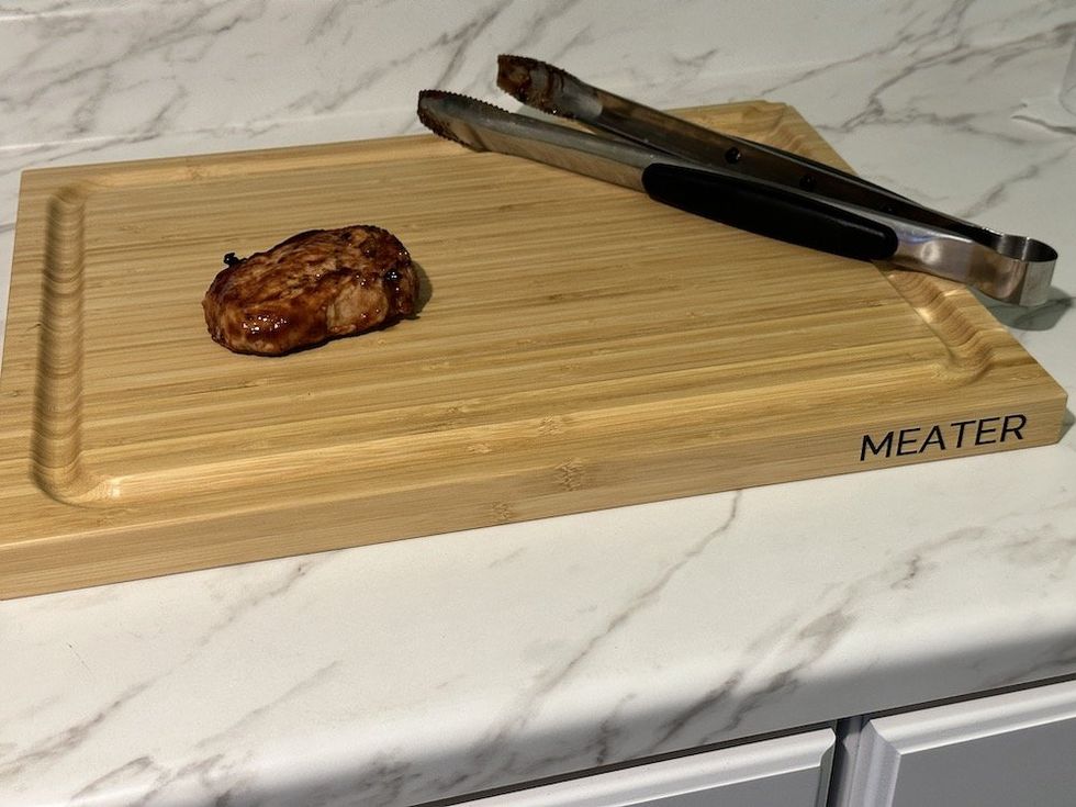 a photo of meater board with meat and bbq tools
