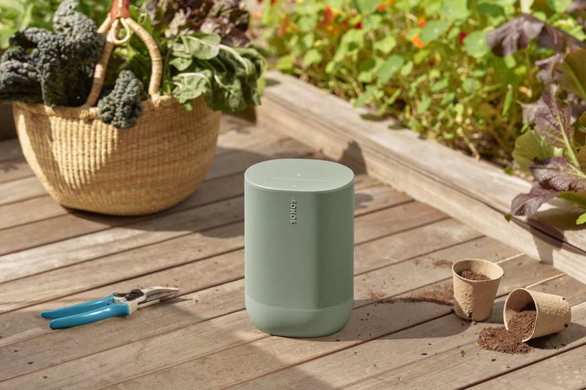 a photo of Sonos Move 2 speaker on a deck next to a garden