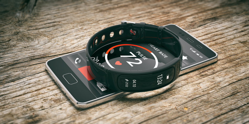 a fitness tracker sittiing on top of a smartphone