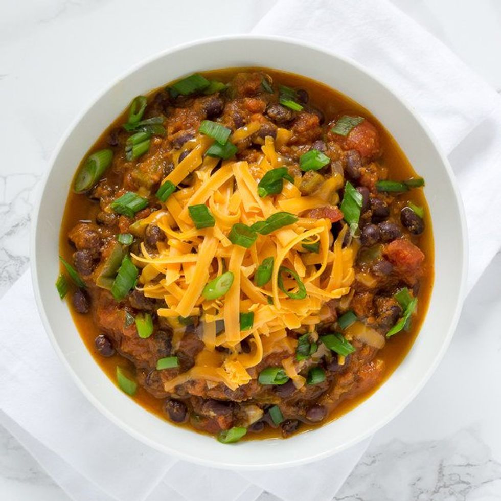 bowl of chili with cheese and green onions on top