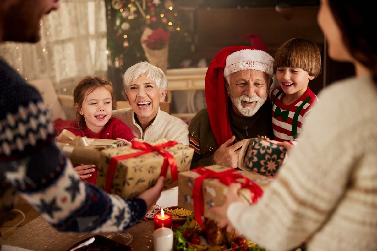 a photo of grandchildren giving grandparents holiday gifts