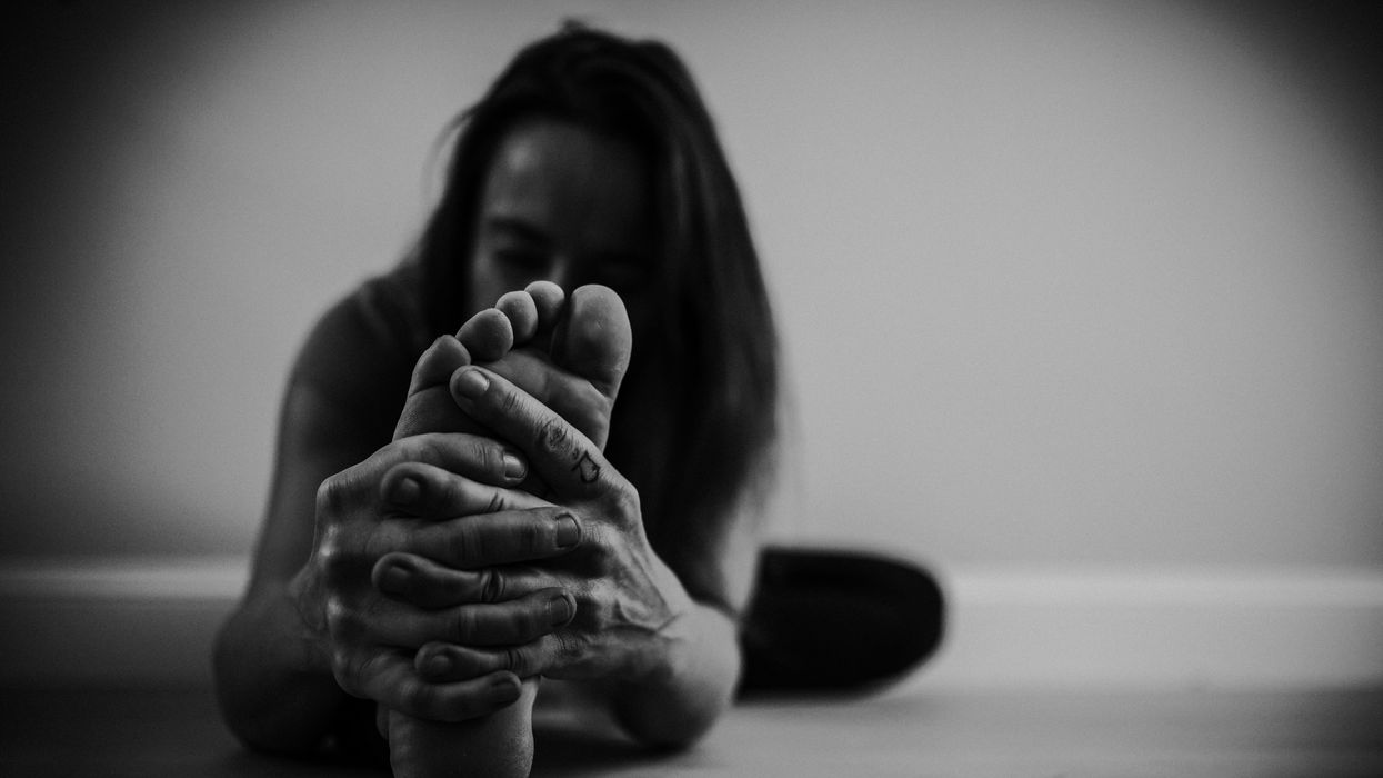 A woman stretching and holding her foot
