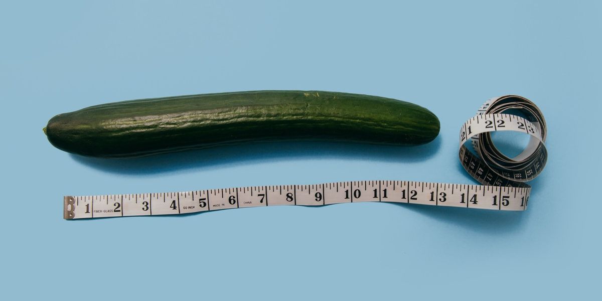 A cucumber, sits along side measuring tape.