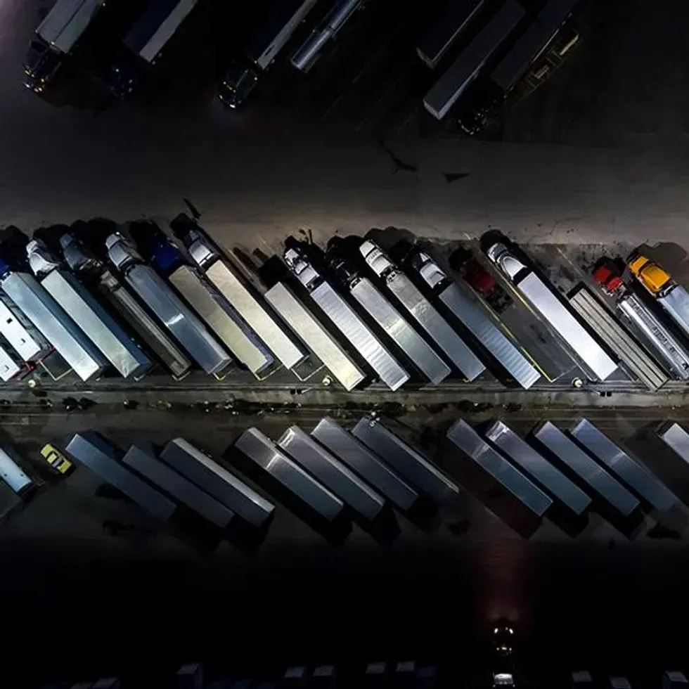 Many semi-trucks parked in a lot