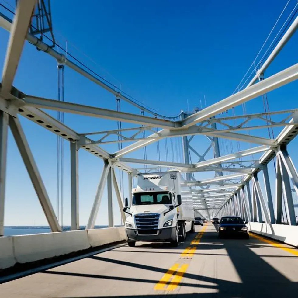 Penske truck driving safely on a bridge