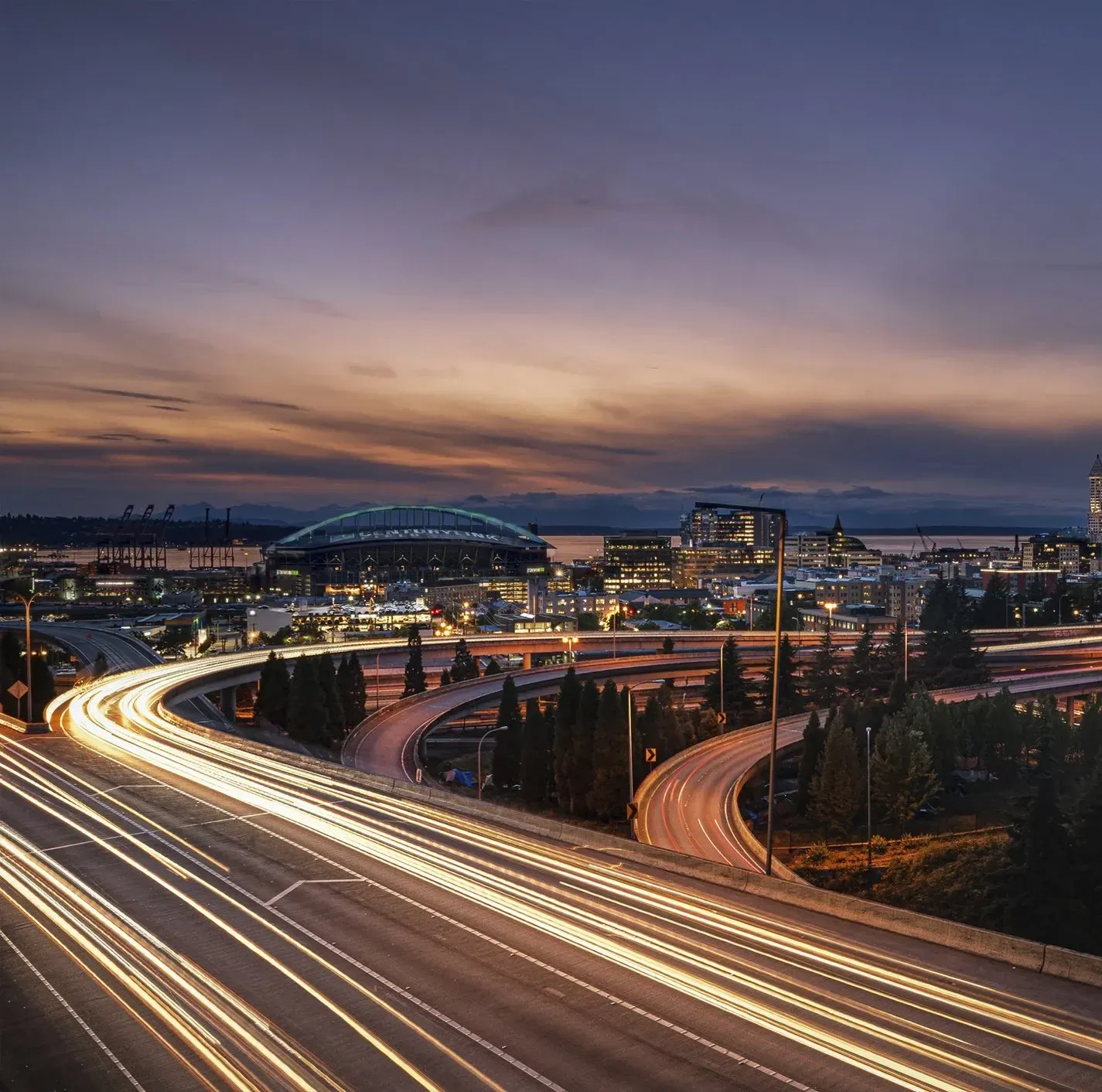 Vehicles speeding down a freeway outside a city at night