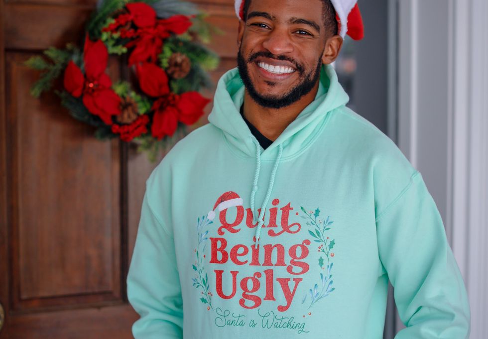 Ryan Jefferson wears the "Quit Being Ugly: Santa is Watching" green hoodie.