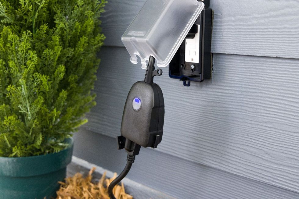 Enbrighten Outdoor Plug-In 2-Outlet WiFi Smart Switch plugged in to an outdoor outlet