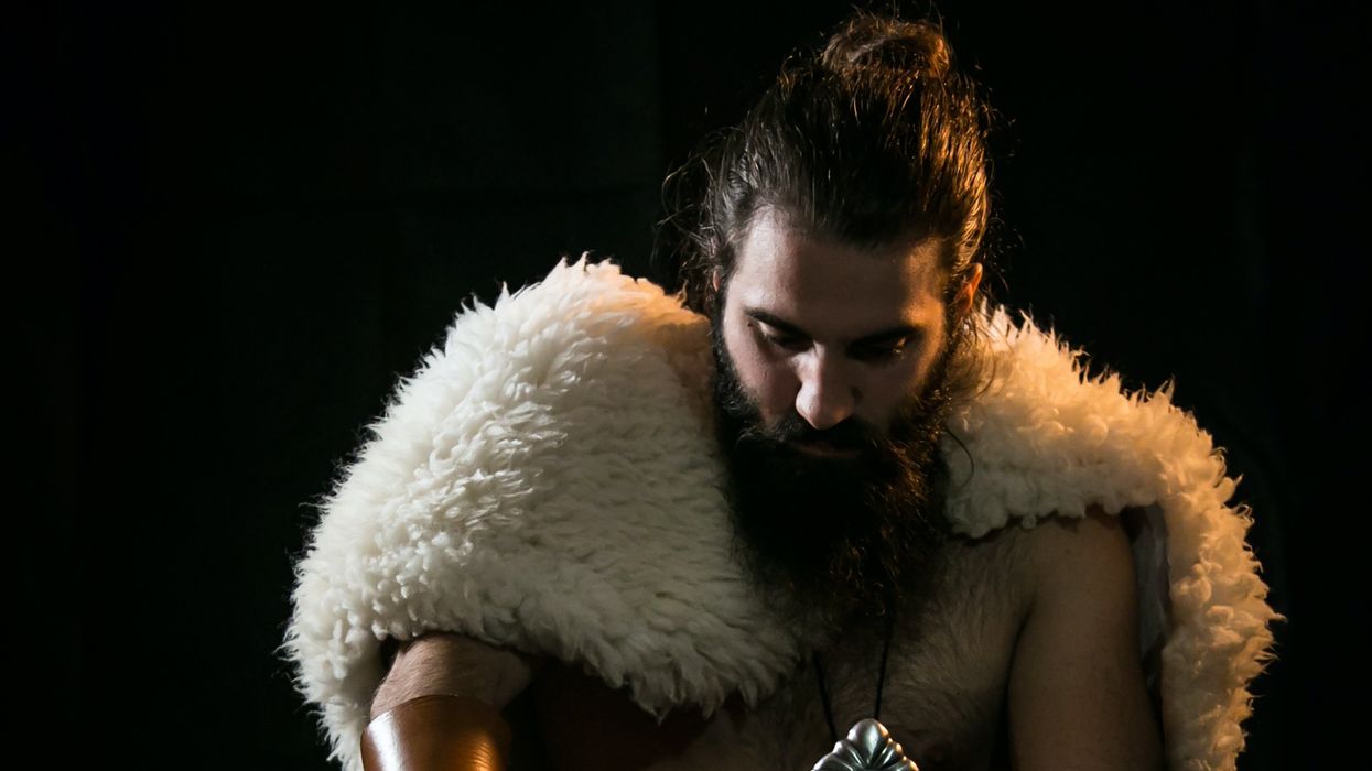 A warlord dawns his fur coat while preparing for a battle during the apocalypse.