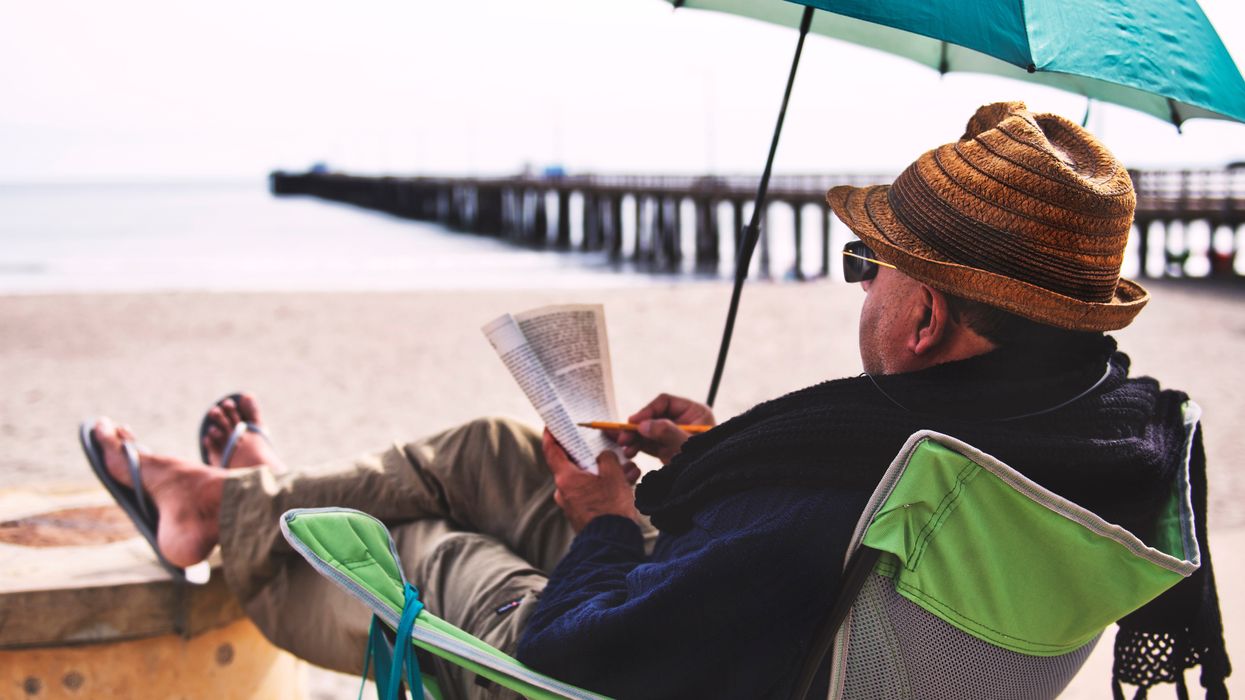 A man reads his favorite book on the beach while watching the apocalypse unfold.