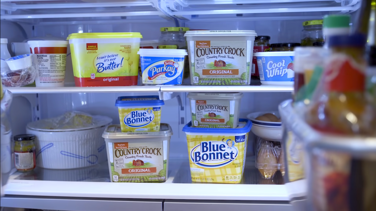 An open fridge full of various brands of butter.