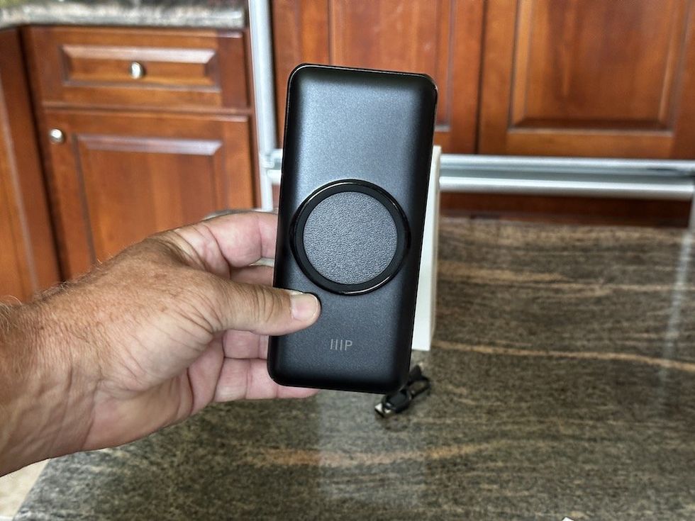 a photo of a hand holding Monoprice 20,000 mAh Power Bank with Wireless Charging