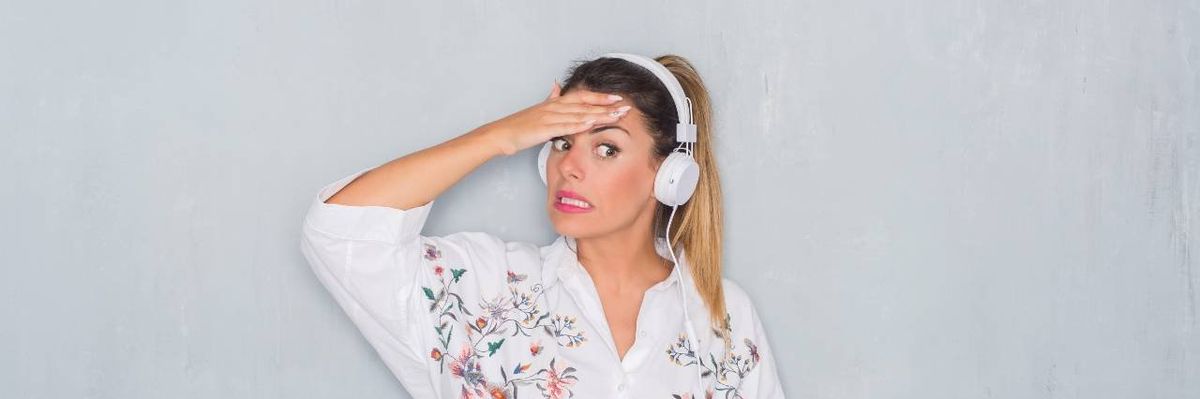 woman with blonde hair in ponytail and wearing headphones has surprised look on her face