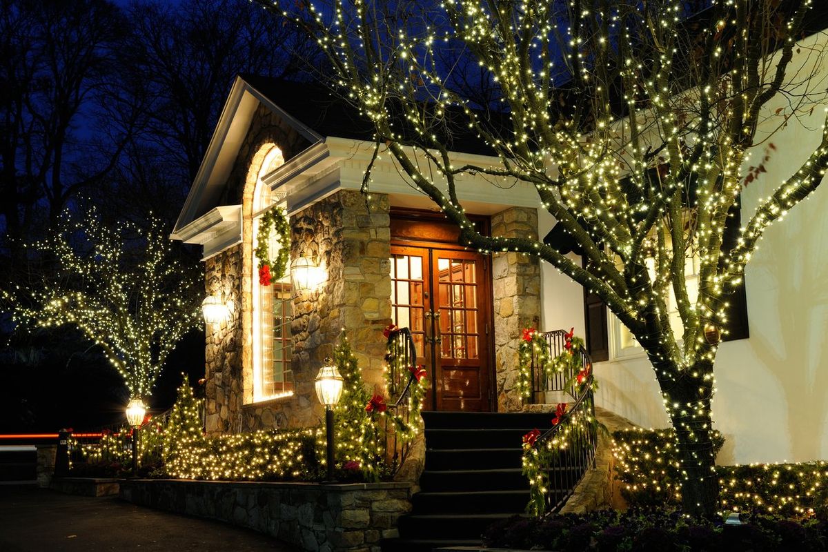 a photo of the outside of a house with holiday lights at night.
